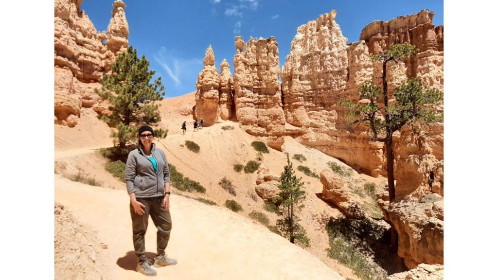 Person on trail with hoodoos behind