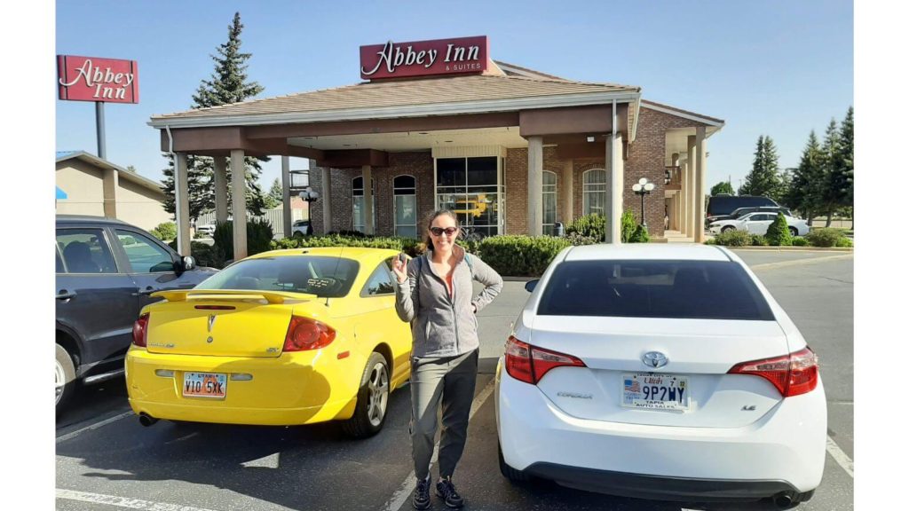 white rental car in front of Abbey Inn for Zion to Bryce Canyon road-trip