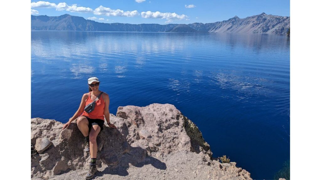 Sitting on a rock at the bottom of the Cleetwood Cove Trail, one of the best Crater Lake hikes