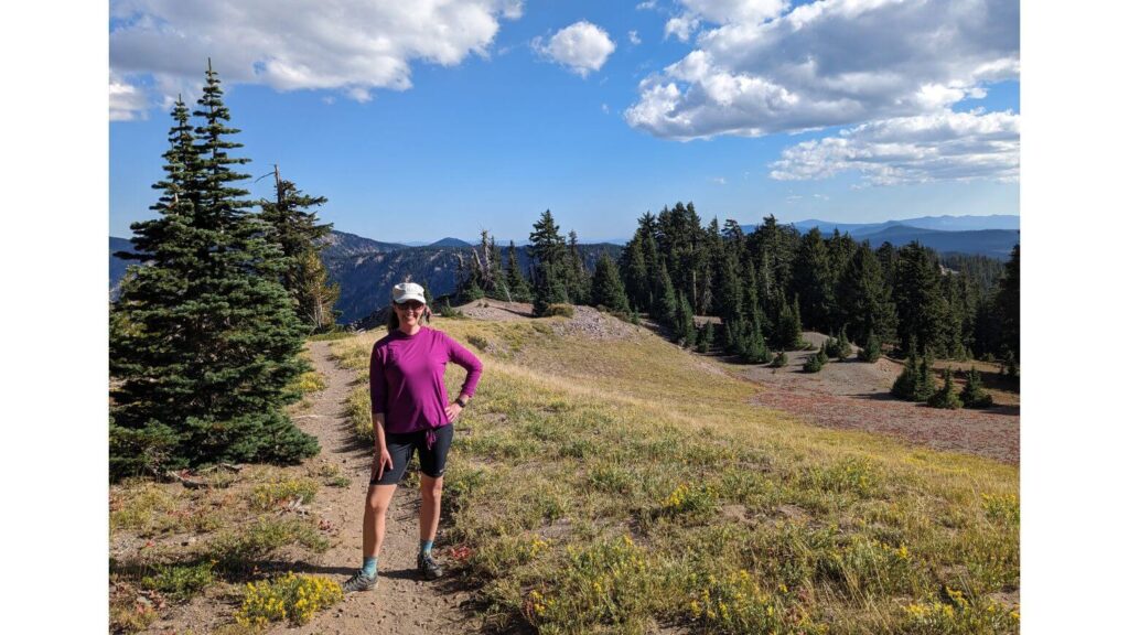 Crater Lake Hikes: Hiker on an open trail with trees in the background