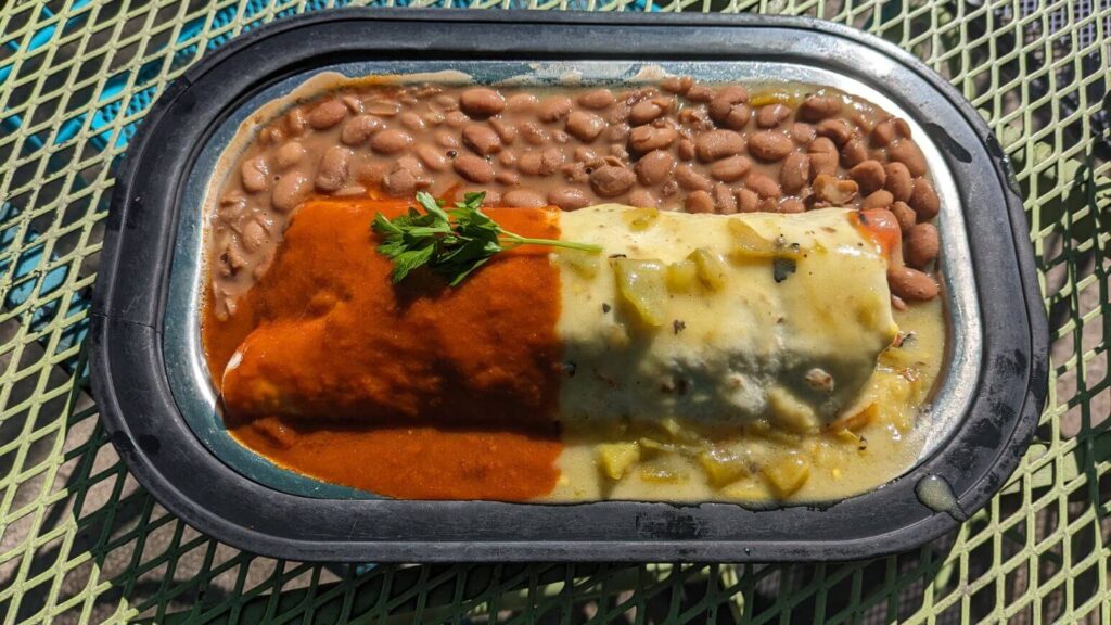 New Mexican Chiles in Burritos: Burrito with red and green chile on top and beans on the side