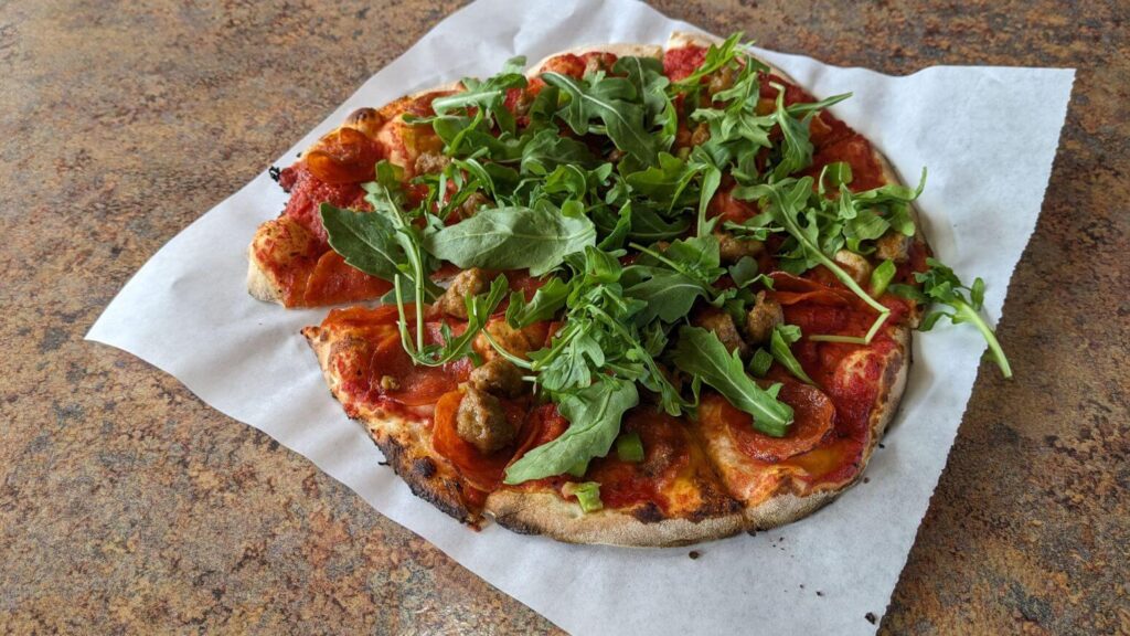 Pizza topped with arugula from Bullman's Wood Fired Pizza in Helena