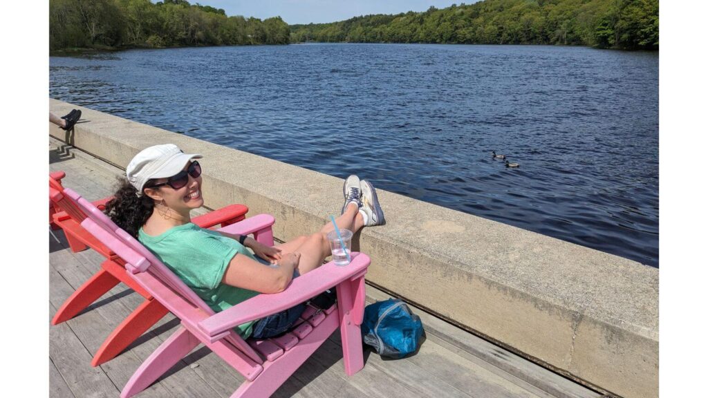 Sitting in a pink Adirondack chair along the Kennebec River