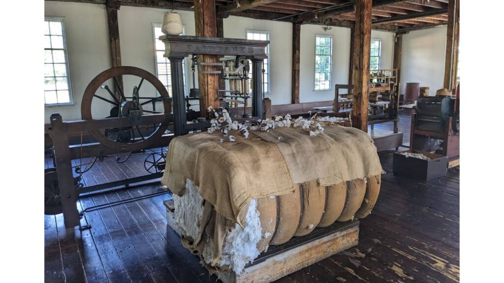 Inside the Old Slater Mill with machinery and a cotton bale - historical sites in Rhode Island